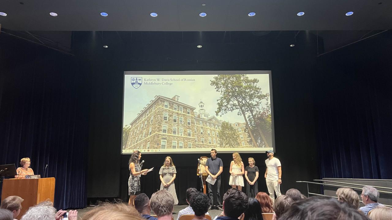 A group of people stand on a stage during a presentation.