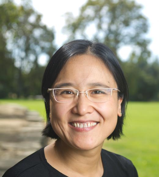 Woman in glasses in front of a grassy field