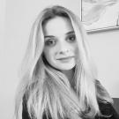 Black and white photo of Jekaterina smiling at the camera.