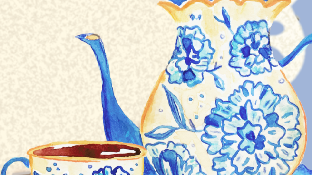 a white teapot and cup with blue floral accents.